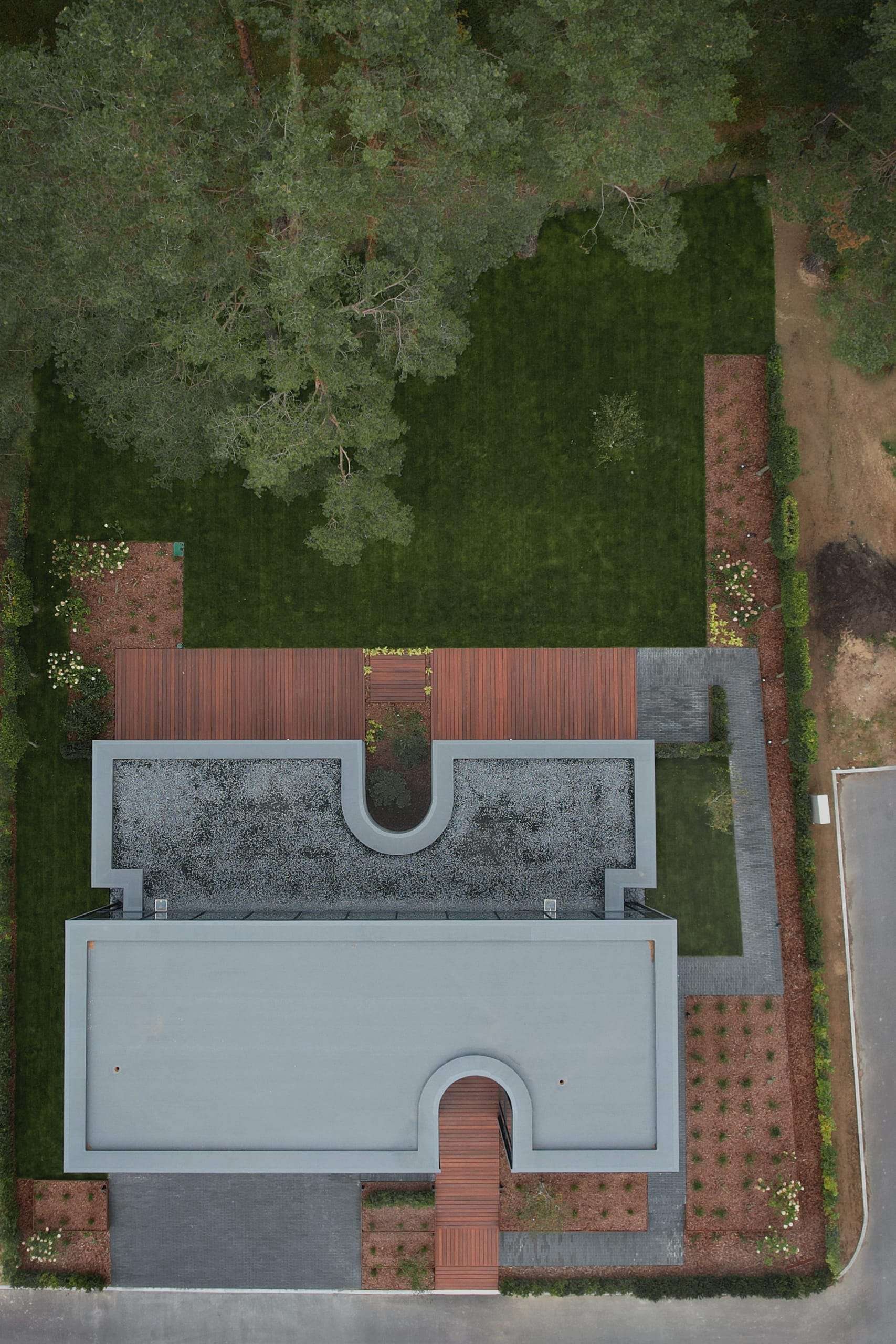 IN JAN House — aerial view of two stone volumes split by a glazed slot