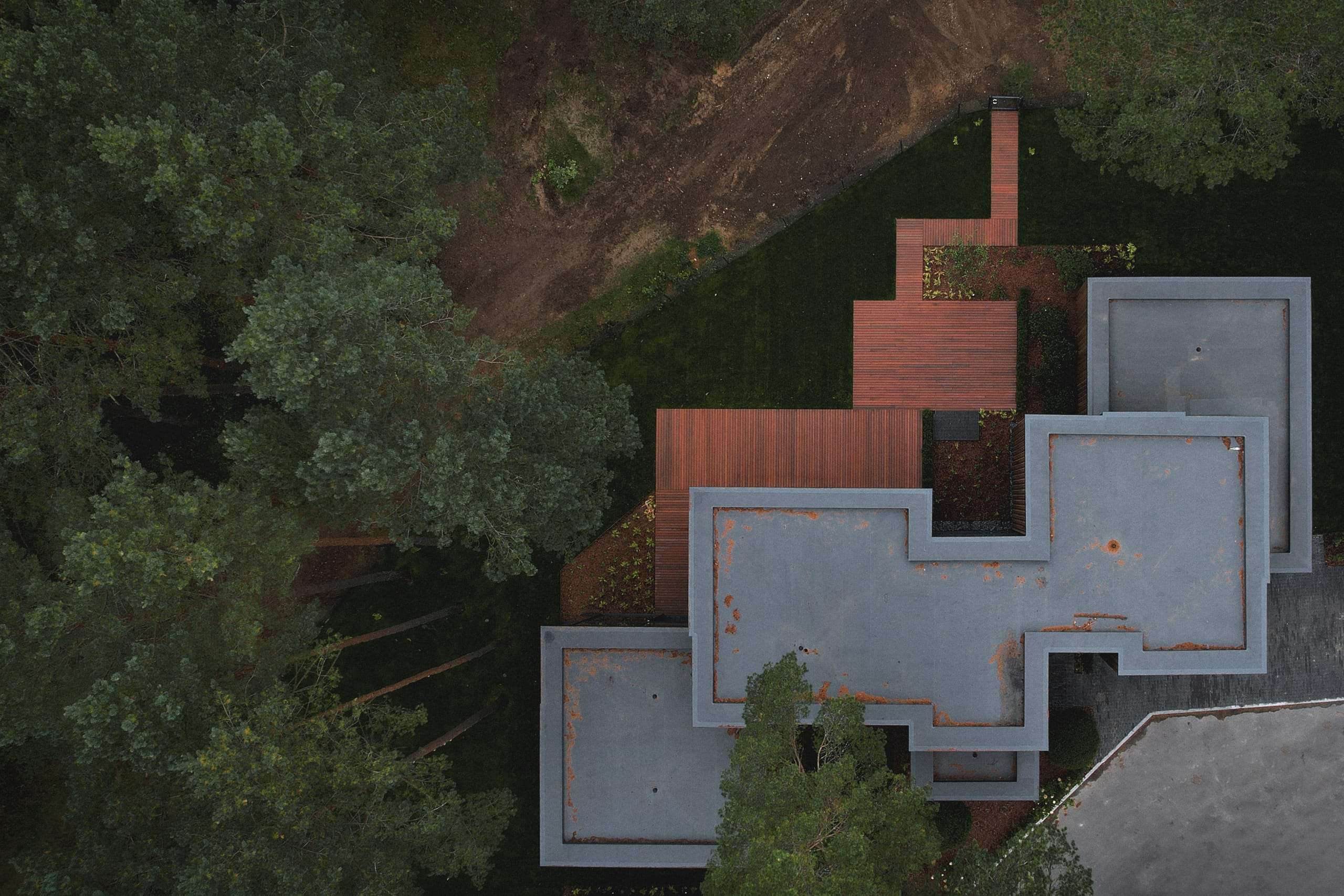 ZEN House — aerial view of interlocking volumes set against the forest