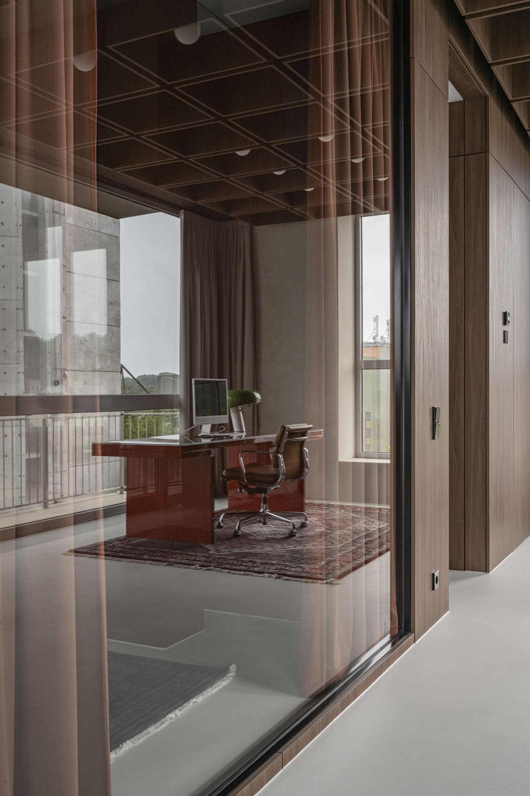 Bespoke Office Interior — red desk and chair beside a wall of windows