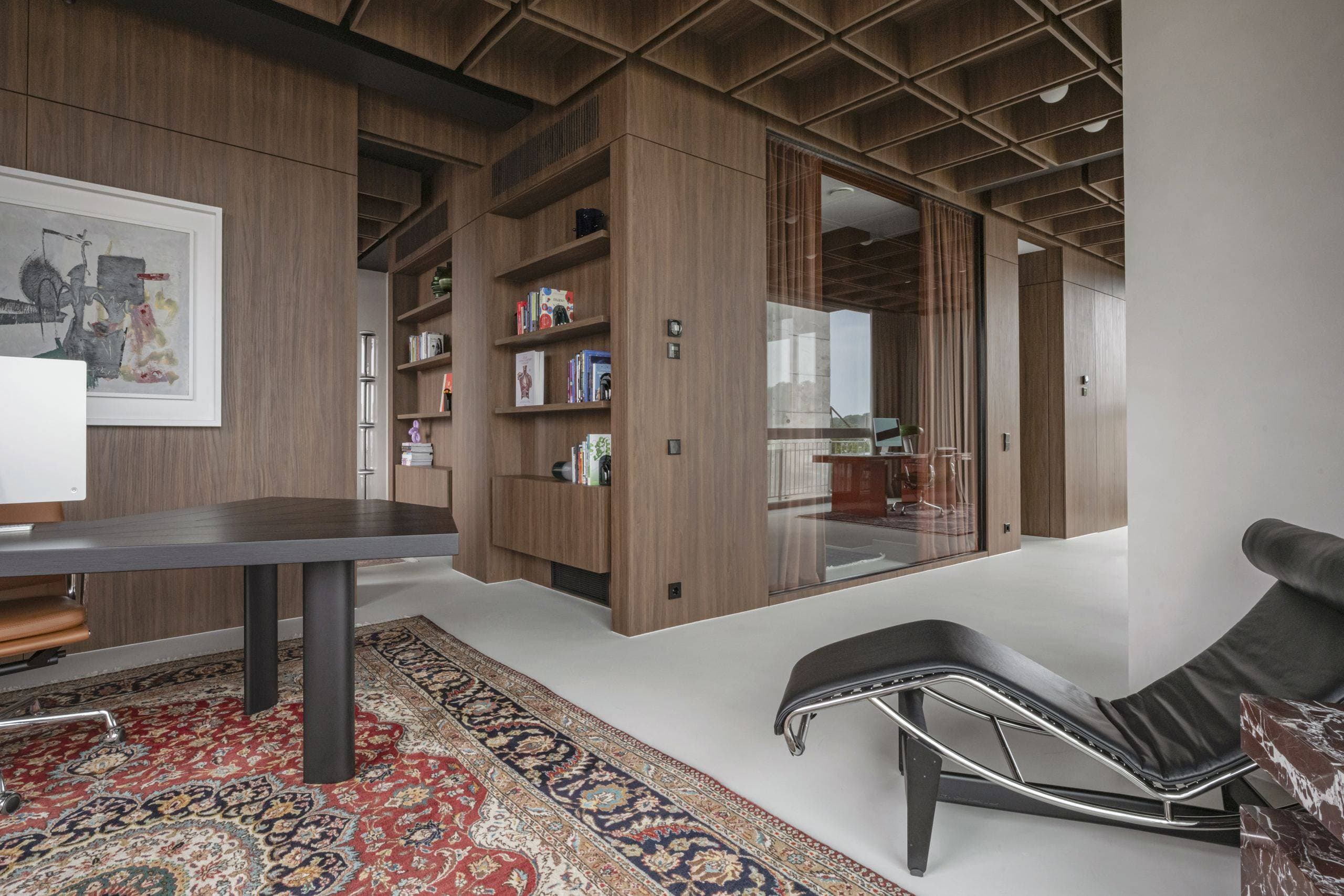 Bespoke Office Interior — dark lounge chair and desk seen through walnut panelling and curtains