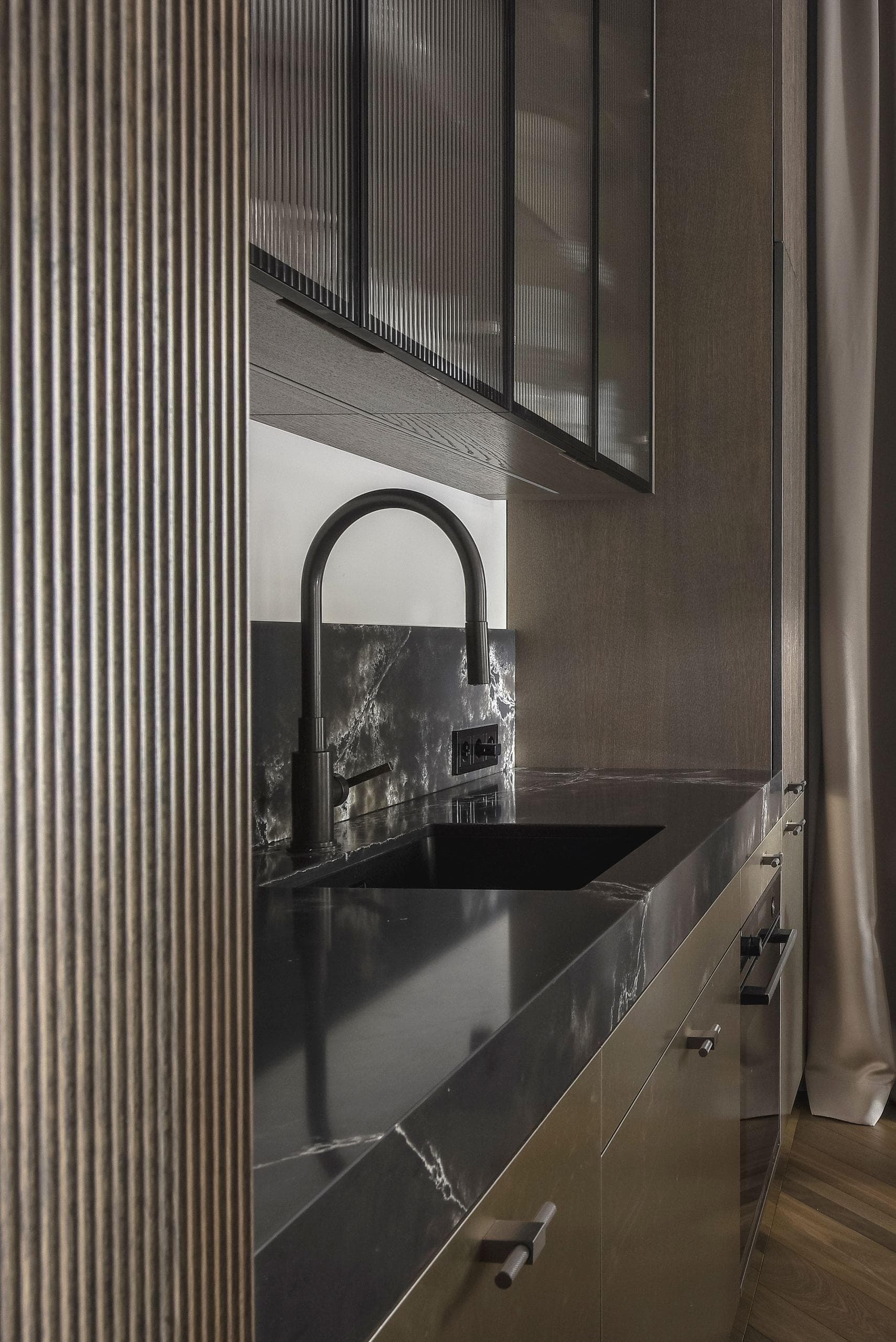 City Avenue Apartment — detail of the ribbed kitchen backsplash and black stone counter