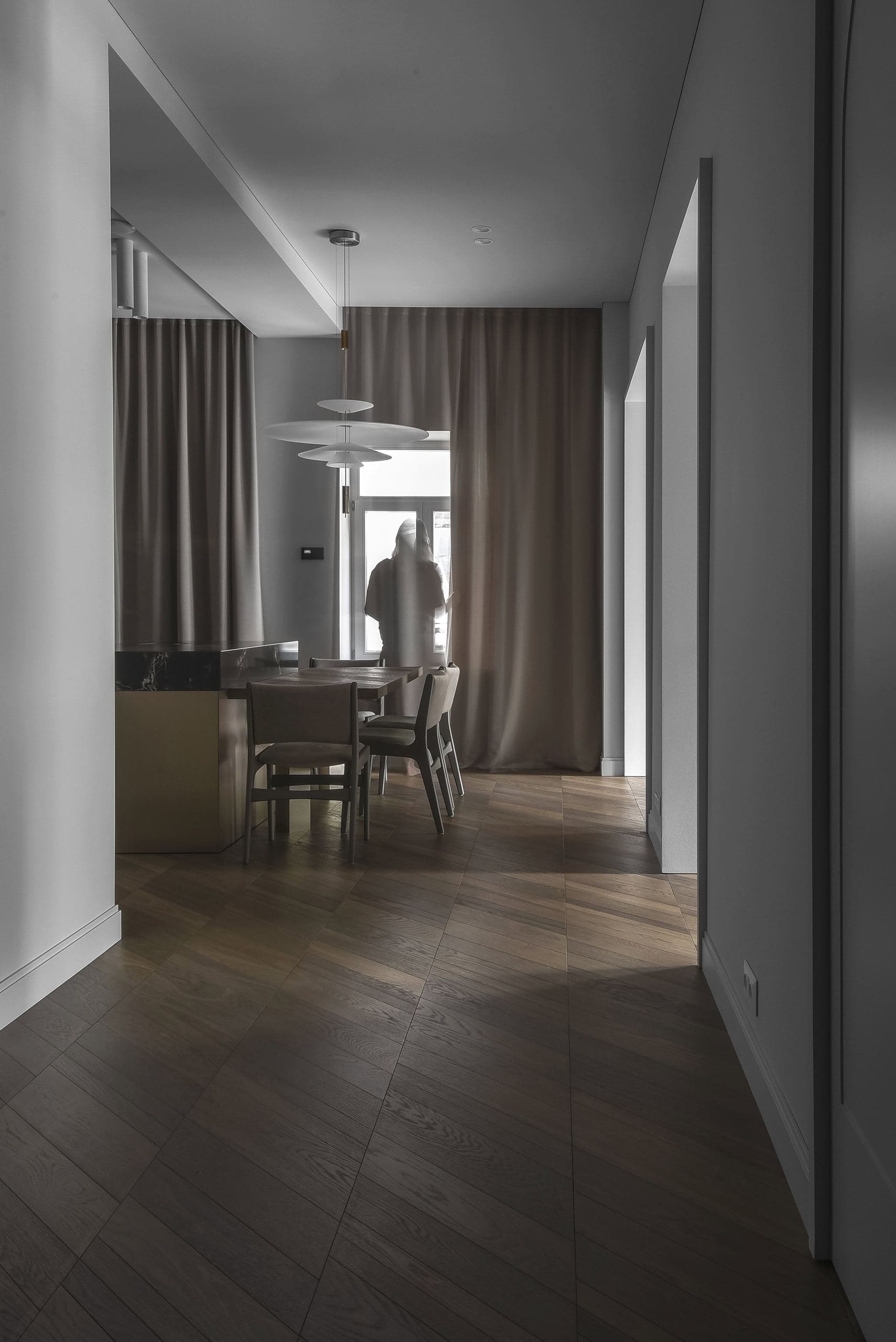 City Avenue Apartment — corridor leading past a dining area to a window