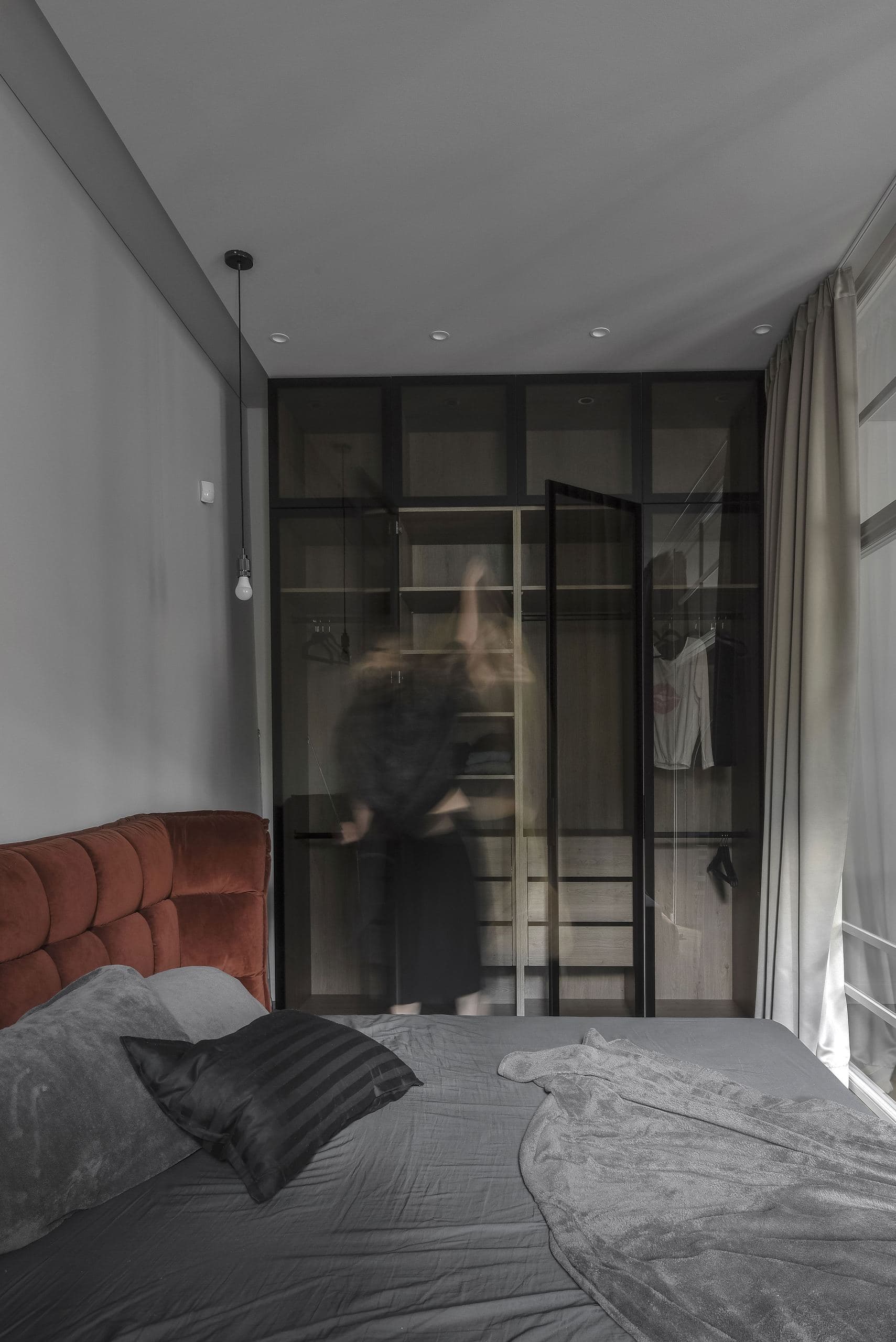 City Avenue Apartment — bed beside a mirrored glass partition