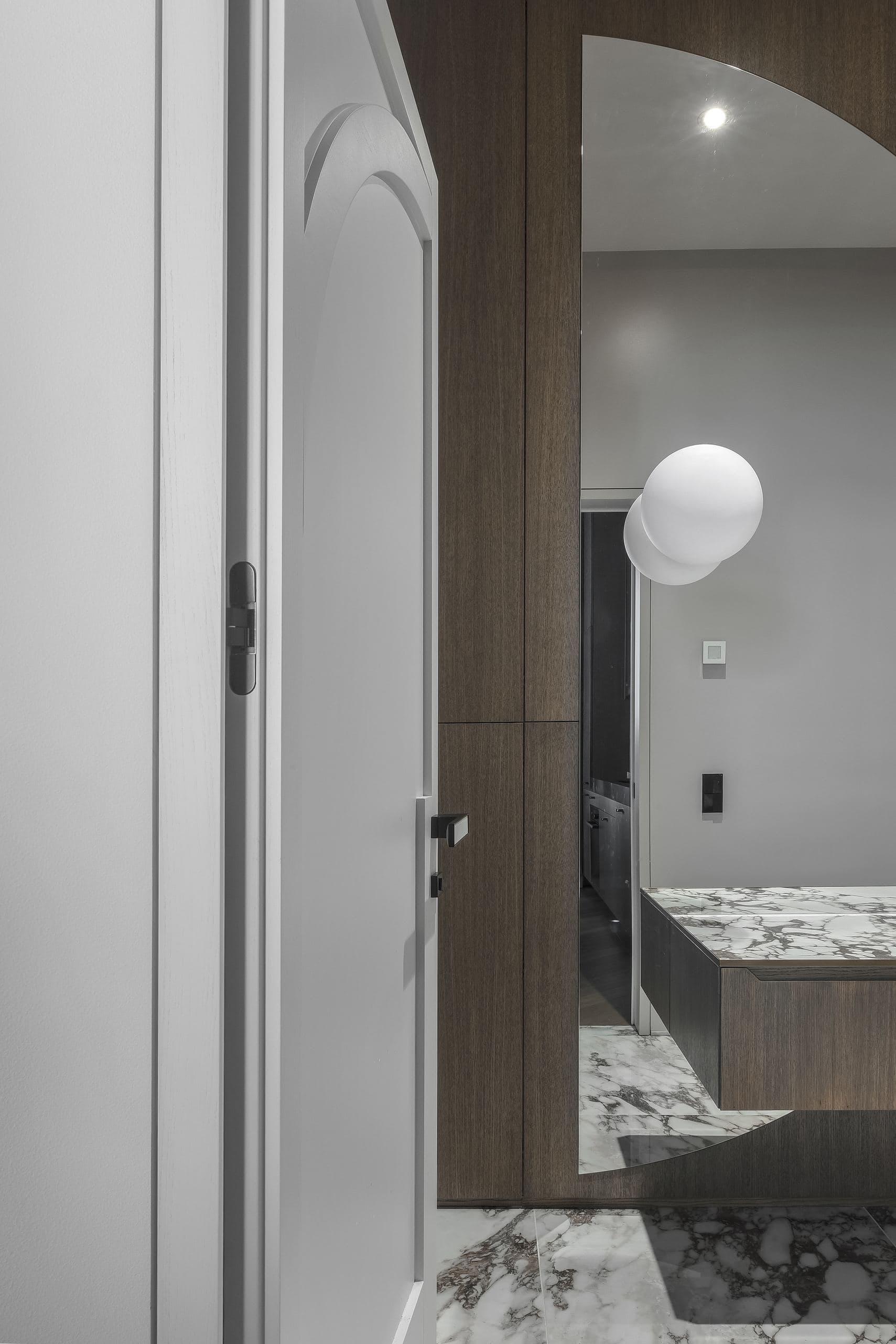 City Avenue Apartment — marble-clad hallway leading to a bathroom door