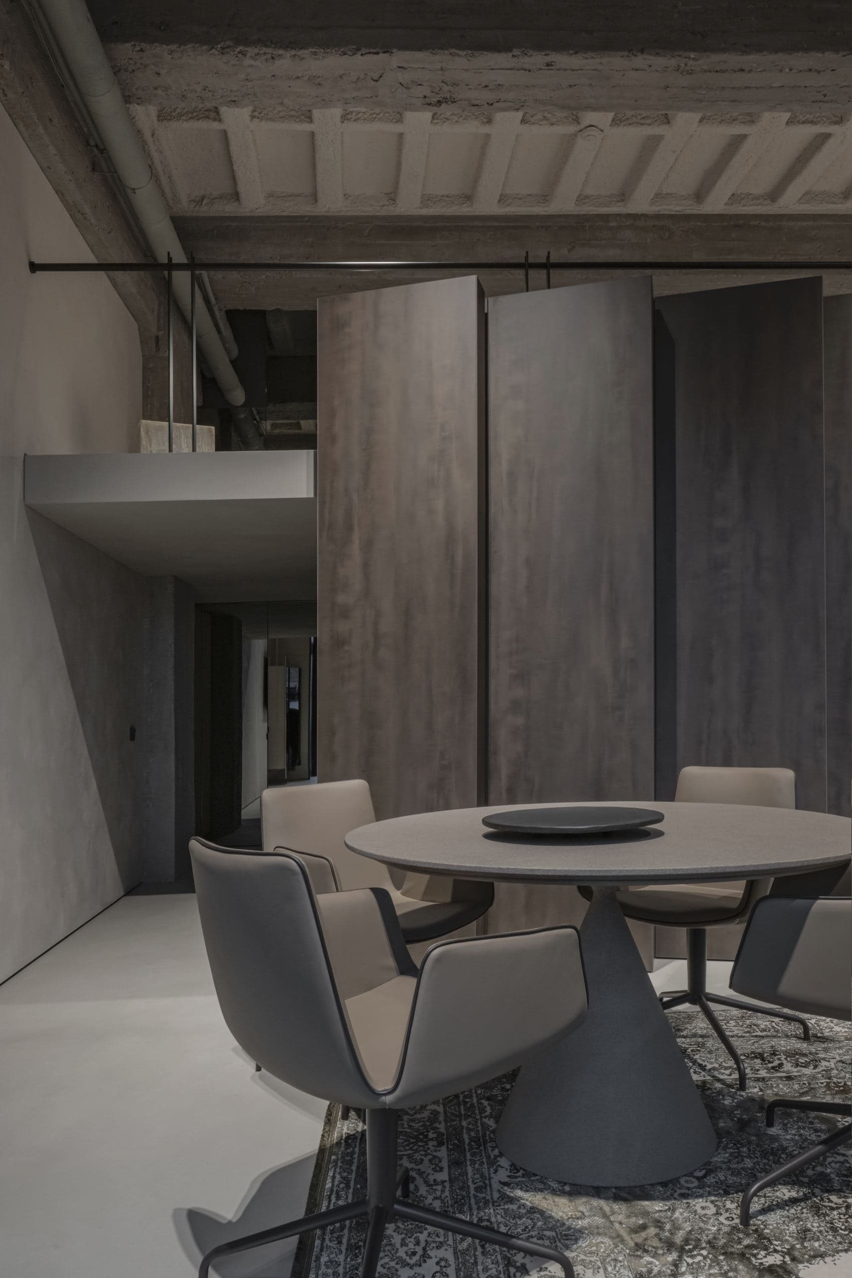 Loft Office — dark timber pivot doors opening beneath the concrete beams