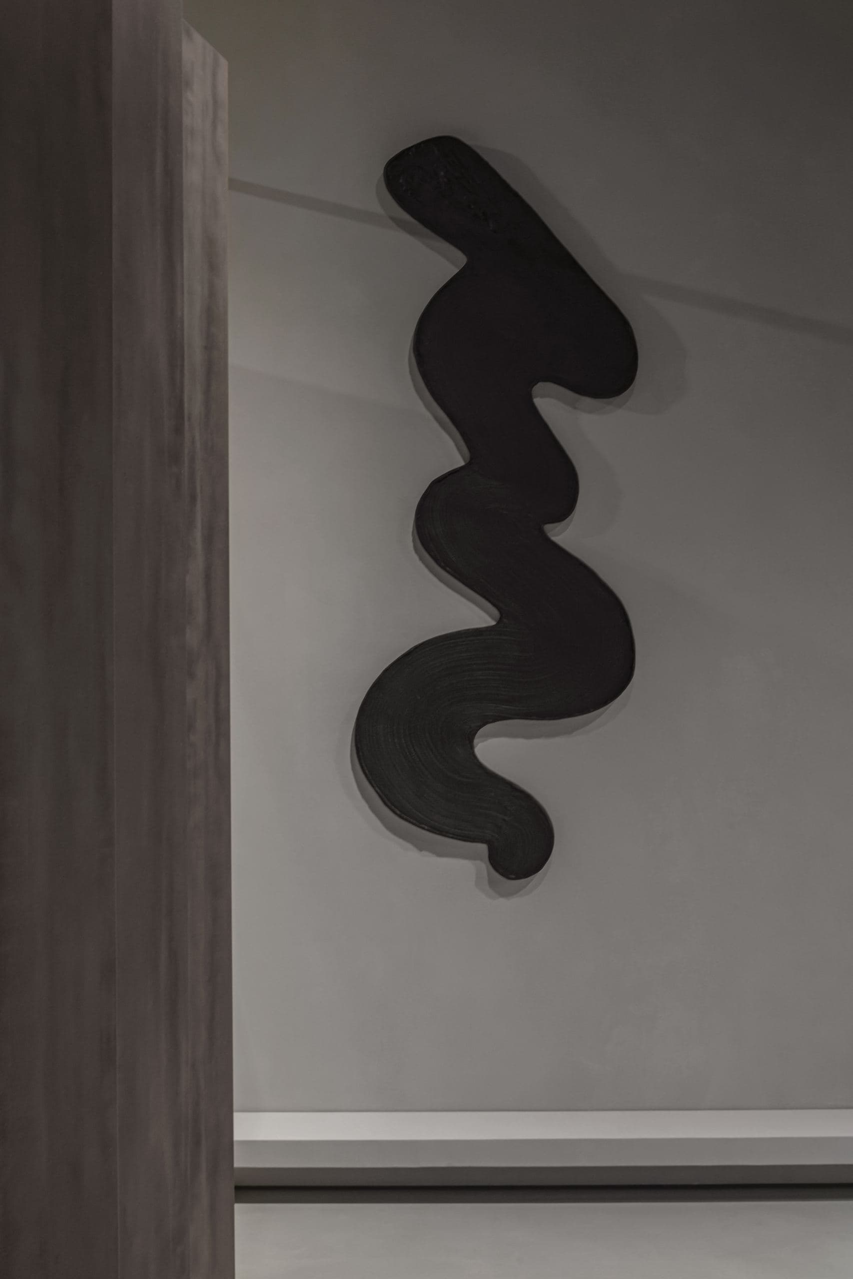 Loft Office — sculptural black wall piece mounted on a plaster wall