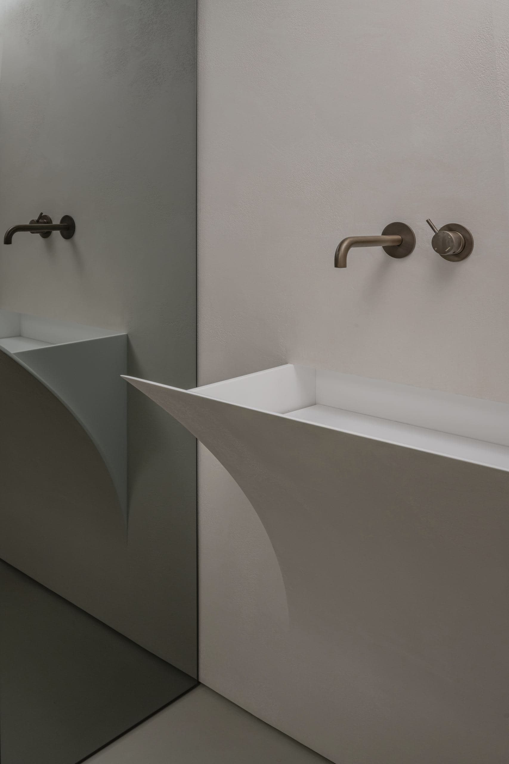 Loft Office — sculptural white stone sink beneath wall-mounted brass taps