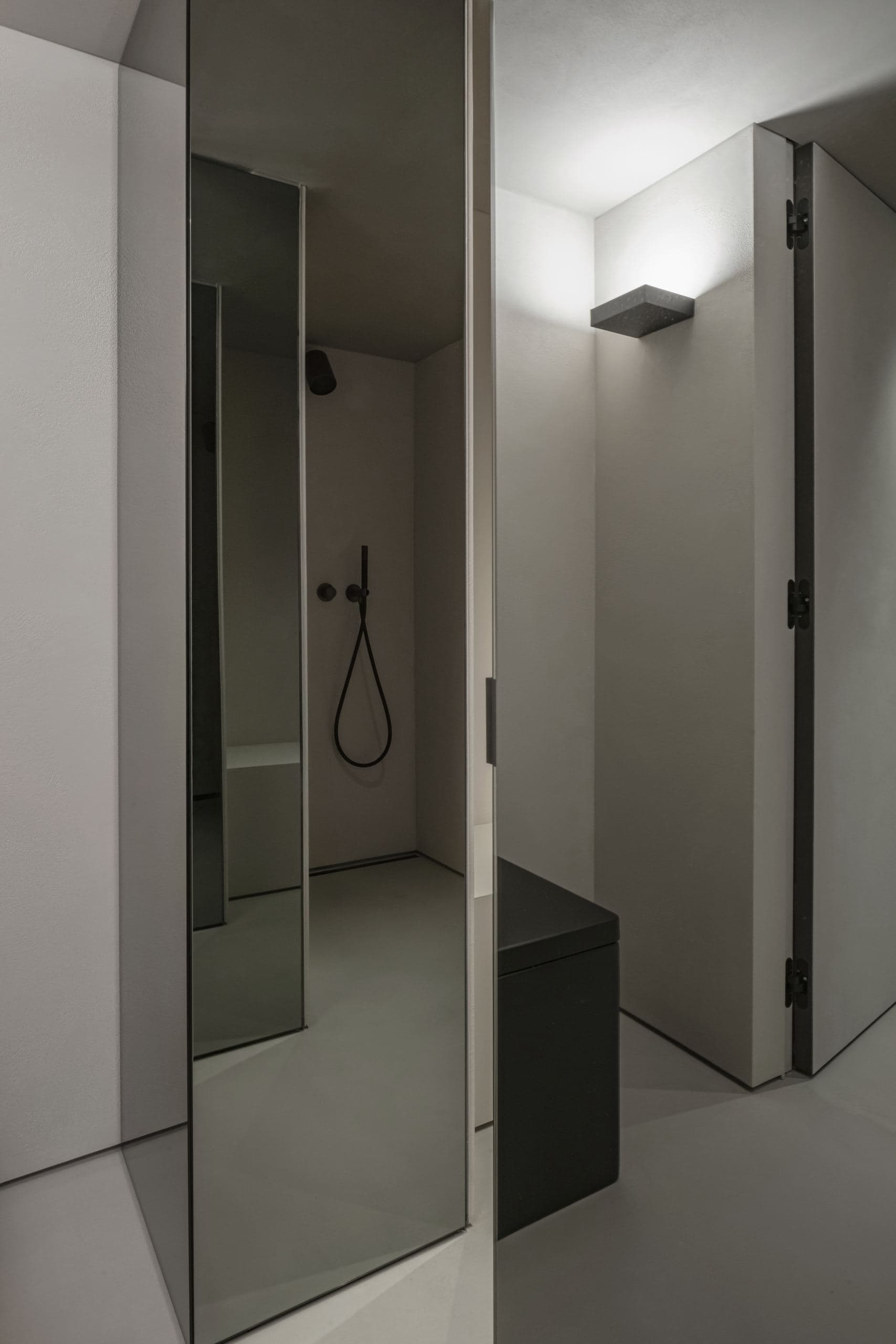 Loft Office — dark door beside a wall sconce and mirrored panel