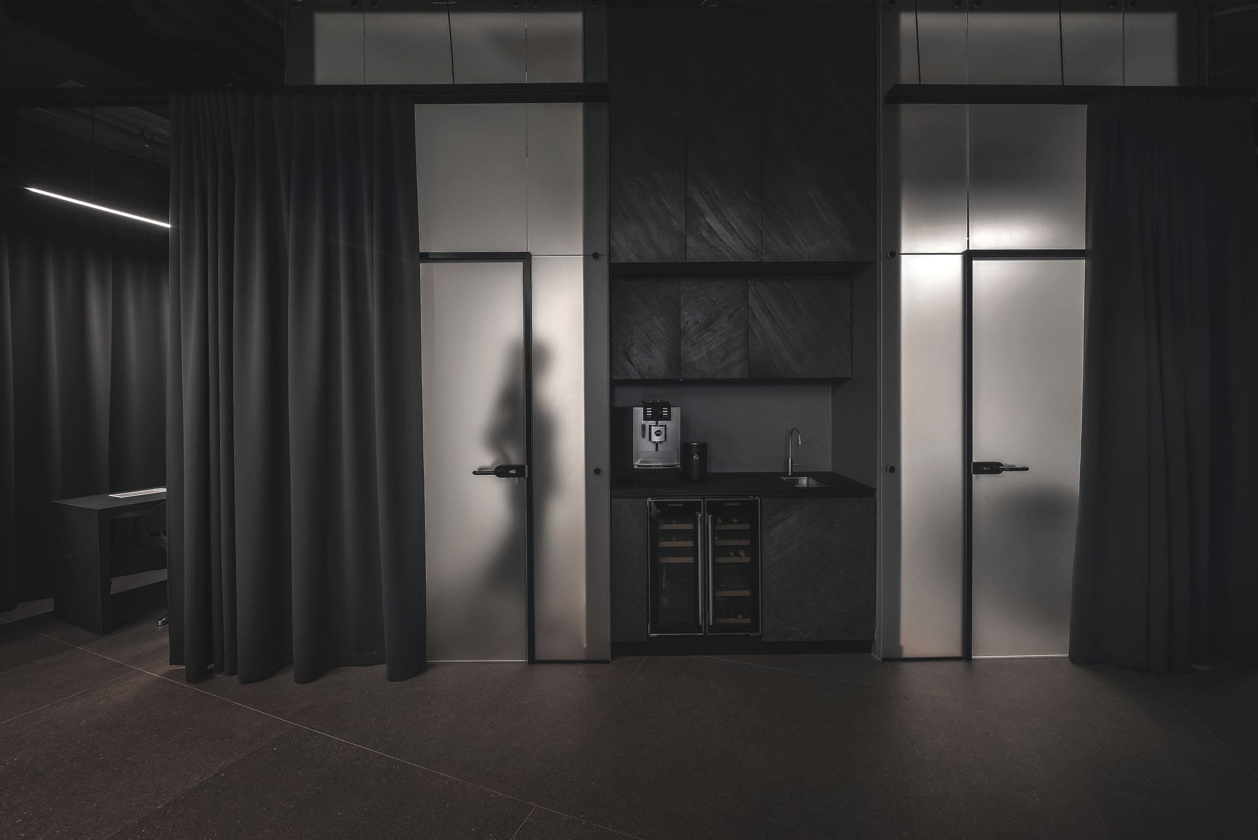 Maestro Beauty Salon — two backlit doors set into a textured dark wall beside a small counter