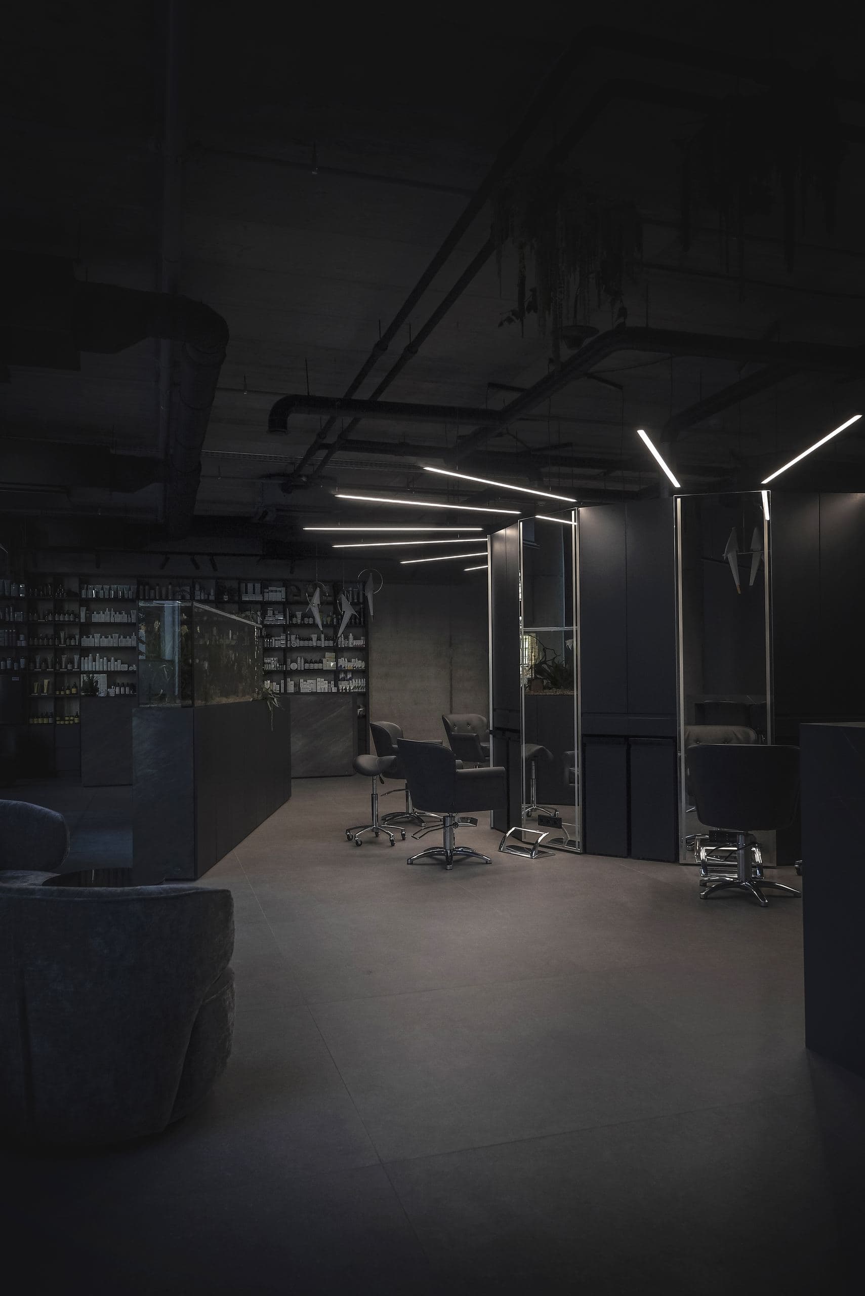 Maestro Beauty Salon — styling stations reflected under ceiling lights and exposed ductwork