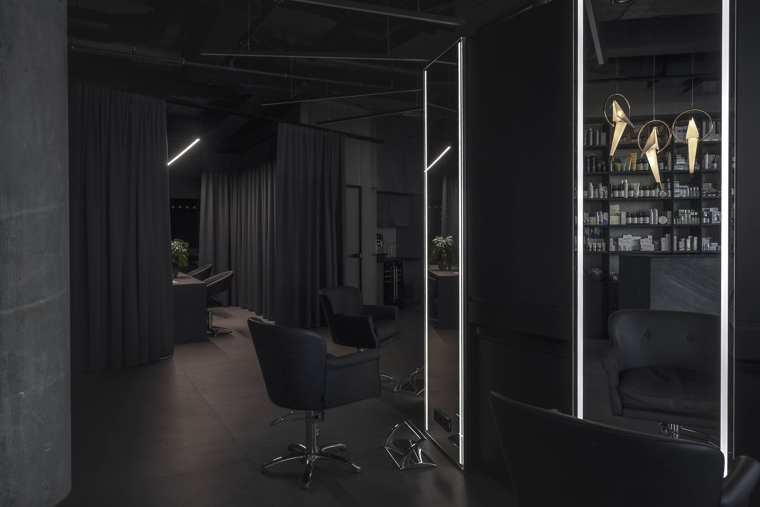 Maestro Beauty Salon — styling chairs and mirrors beside a concrete column and dark curtains