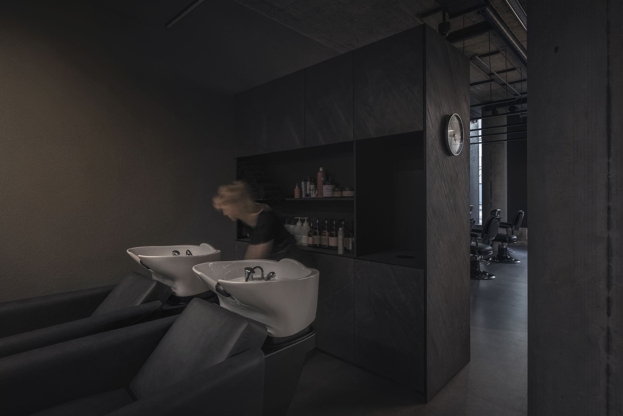 Maestro Beauty Salon — wash basins built into a dark counter beneath the shelving wall