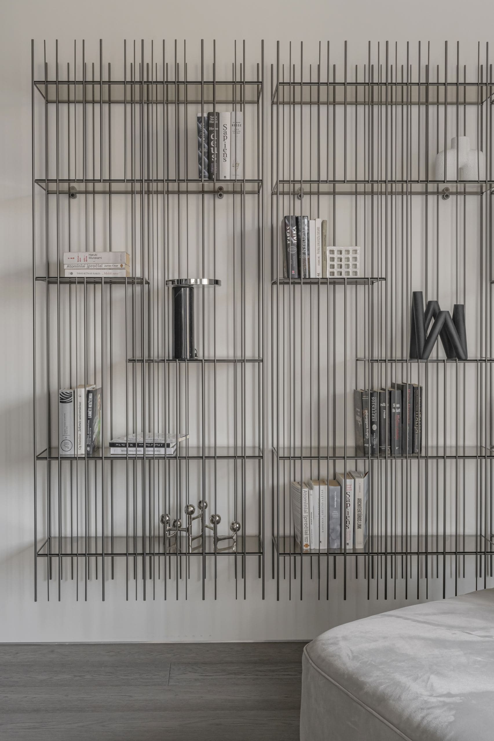 Paupys Apartment — wire shelving styled with books and objects beside the bed