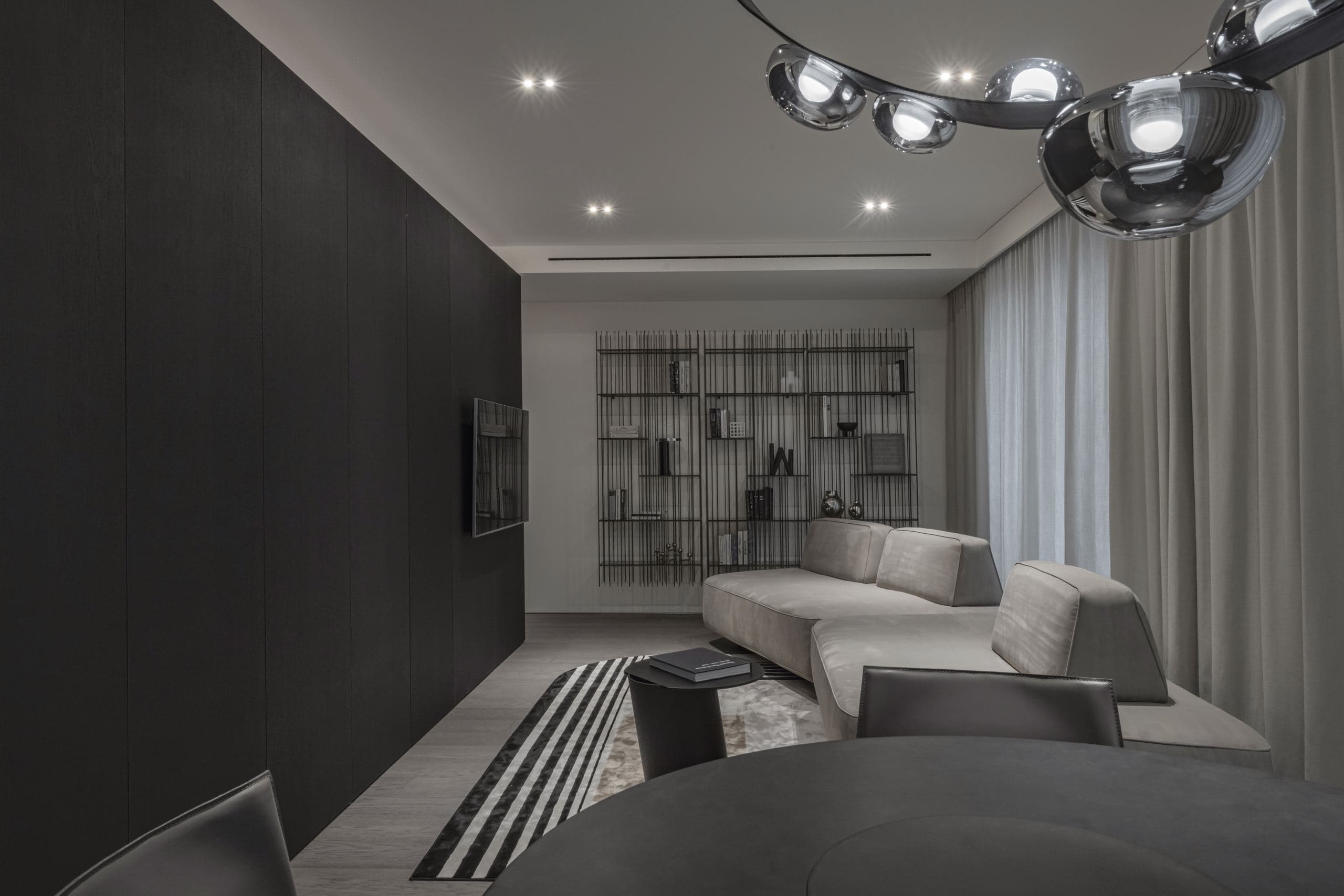 Paupys Apartment — living area's sofa and shelving beneath a striped rug