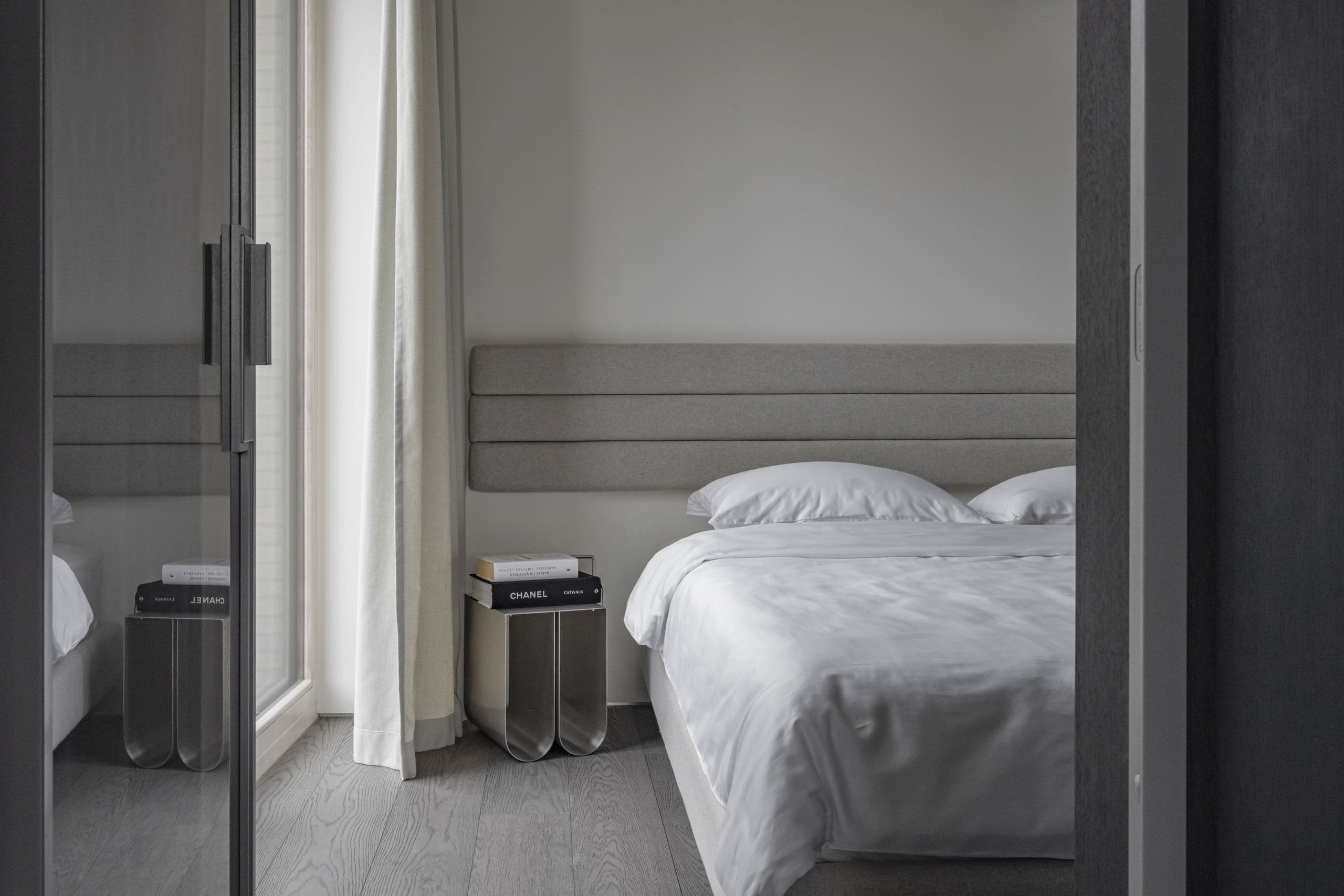 Paupys Apartment — twin beds seen through a glazed sliding door