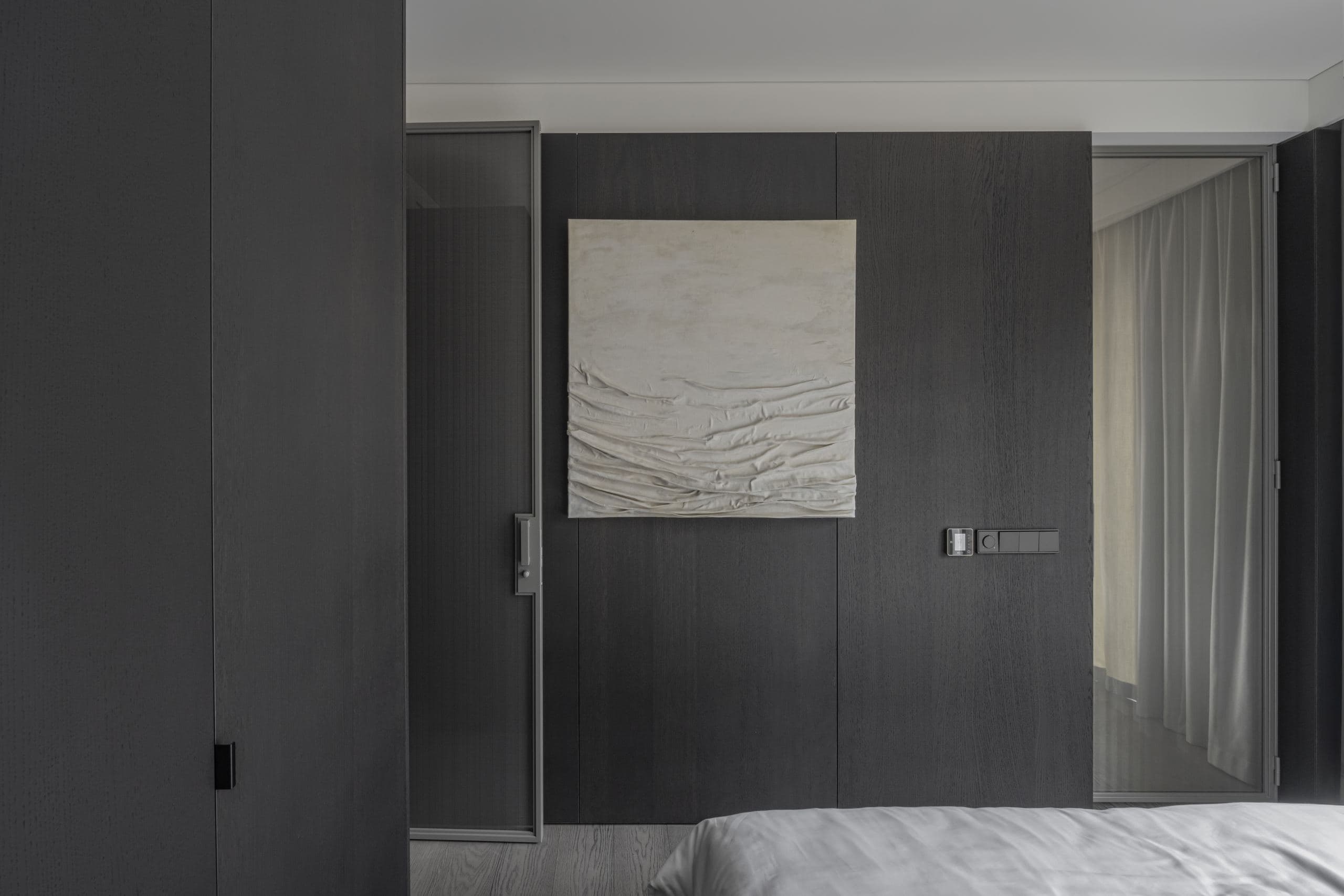 Paupys Apartment — bed beside a small square wall niche in the black volume