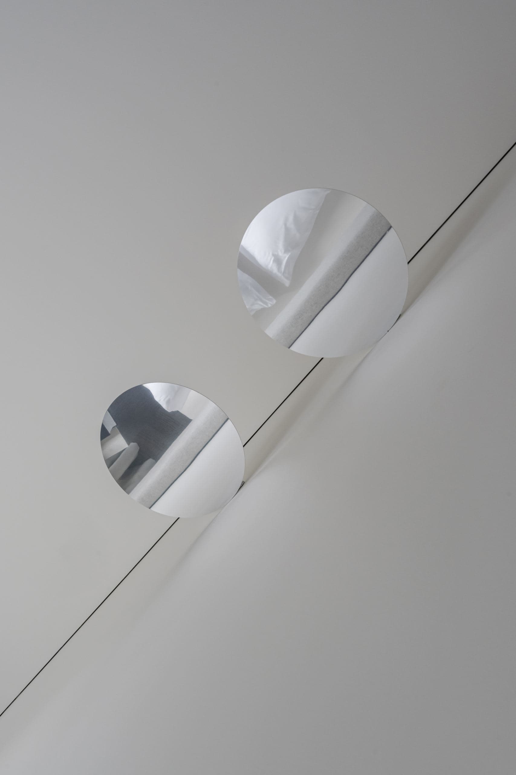 Paupys Apartment — two round mirrored wall lights beside a folding panel