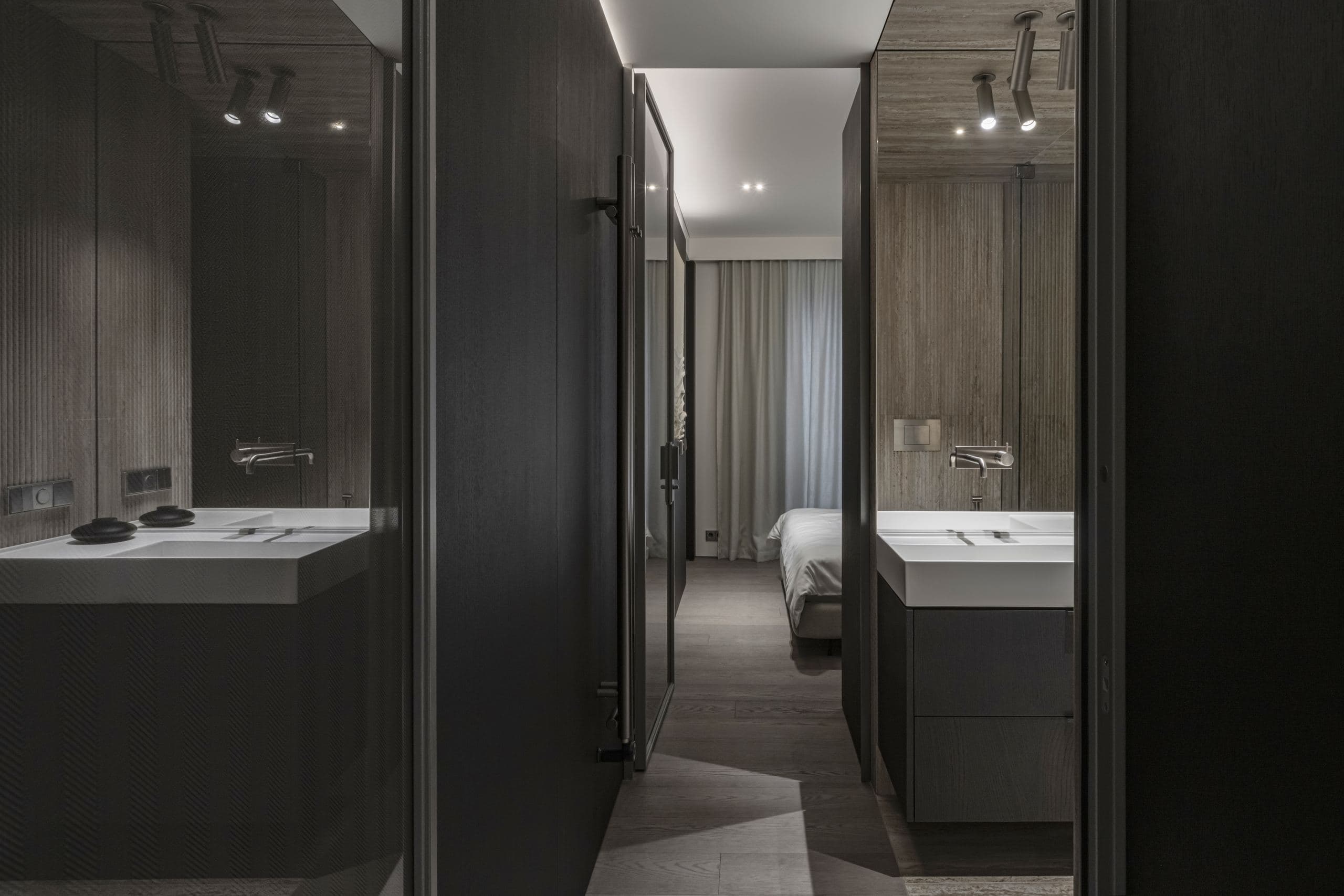 Paupys Apartment — bathroom doors reflecting a bed through mirrored glass