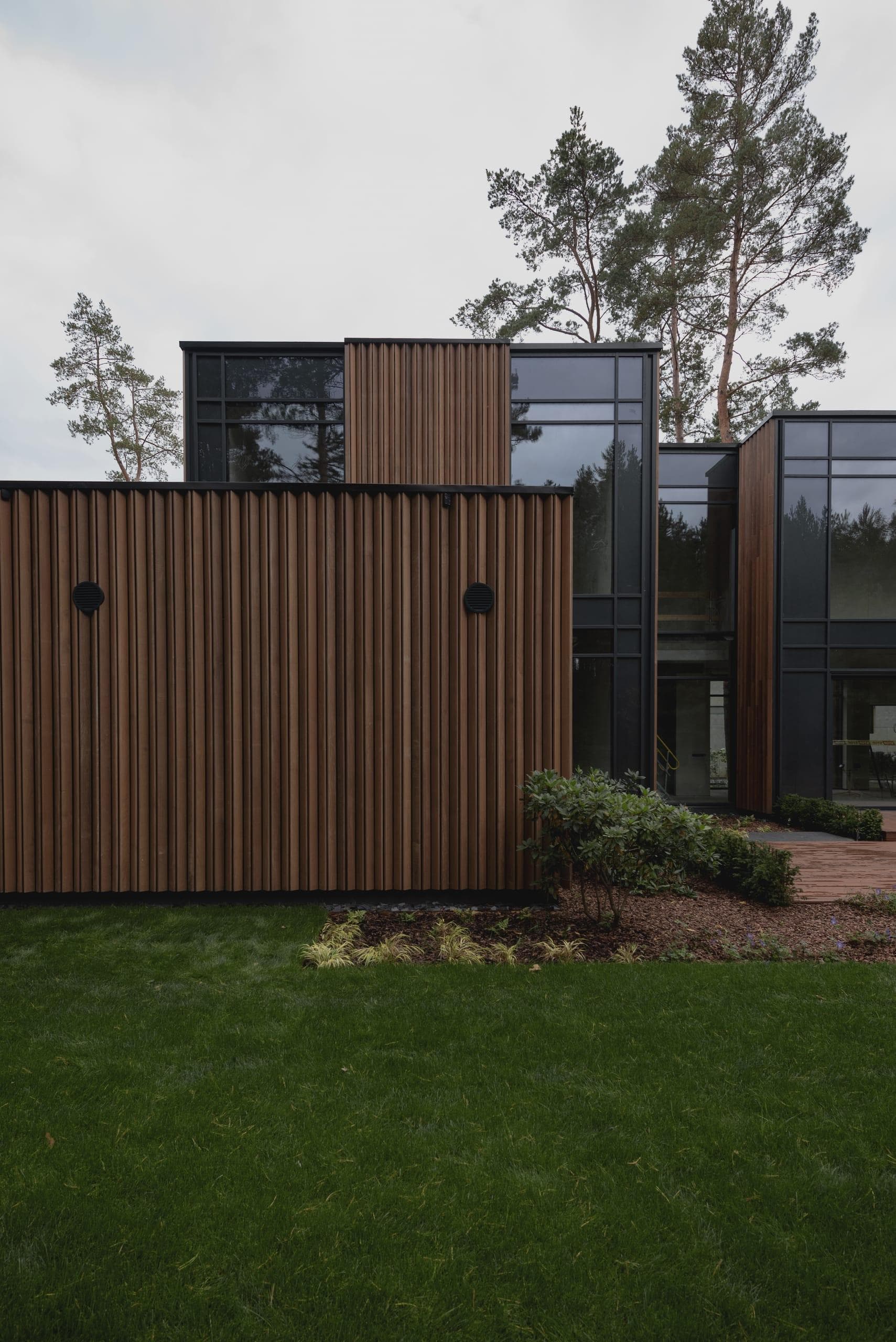 ZEN House — garden elevation, round vents punctuating the timber cladding