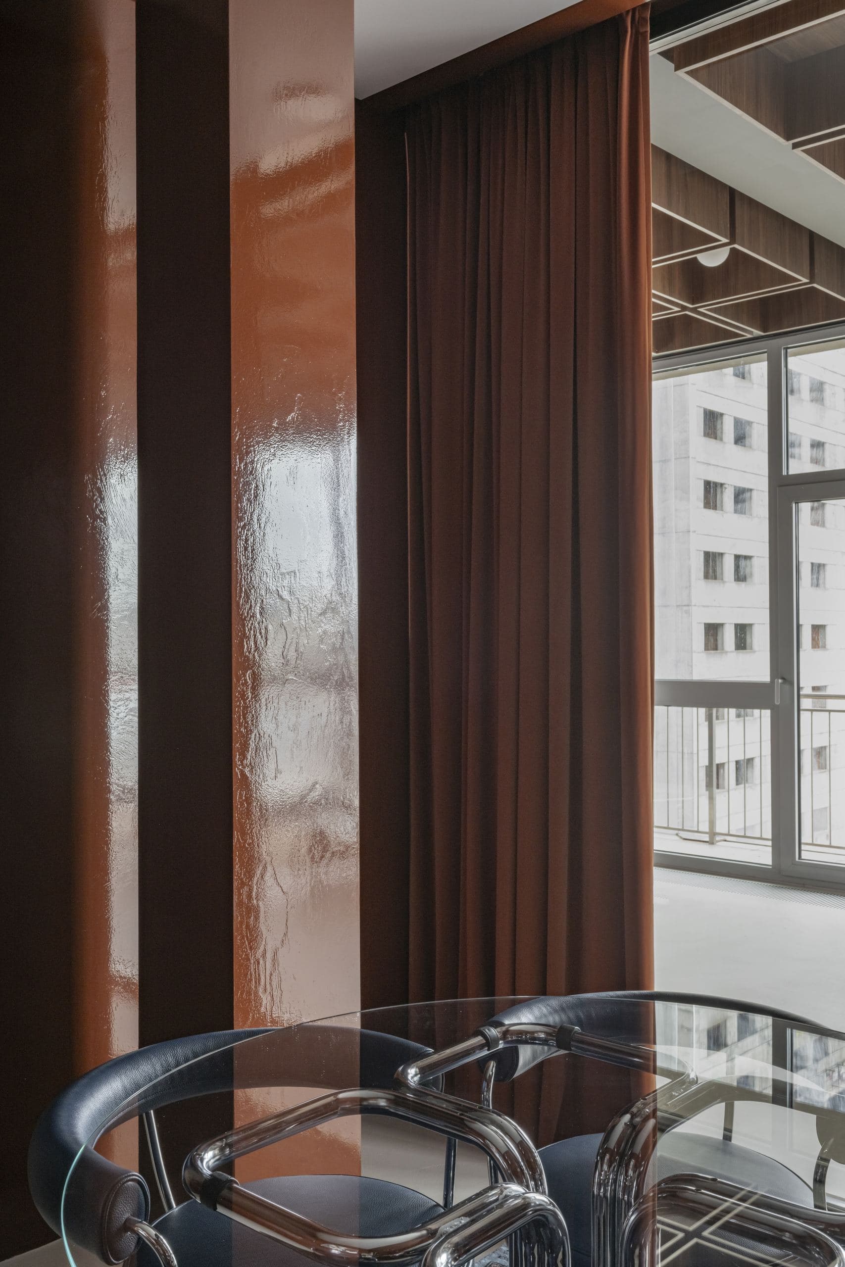 Bespoke Office Interior — chrome and leather chairs beside a rust-coloured lacquered column