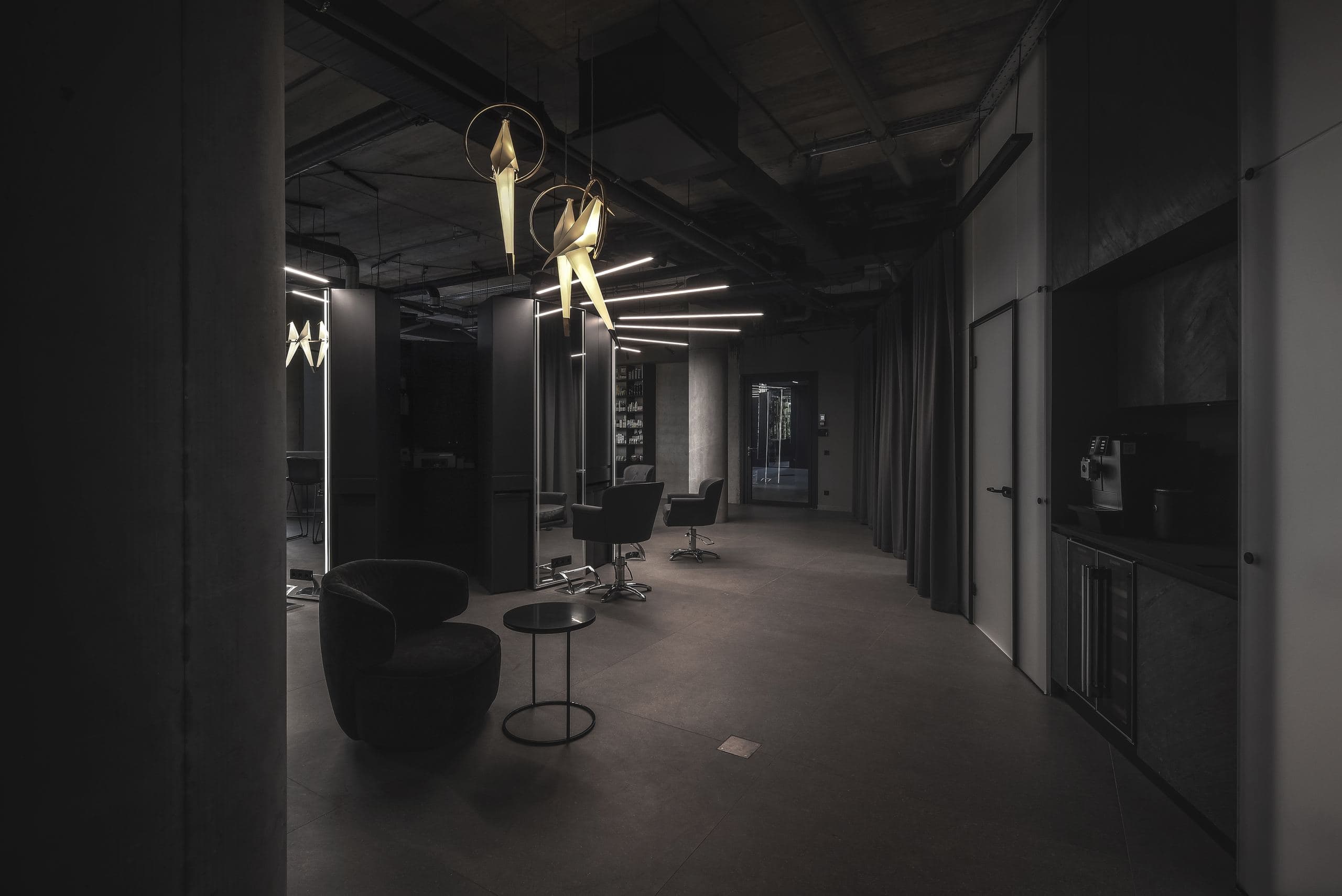 Maestro Beauty Salon — corridor of styling stations lit by gold origami-fish pendants